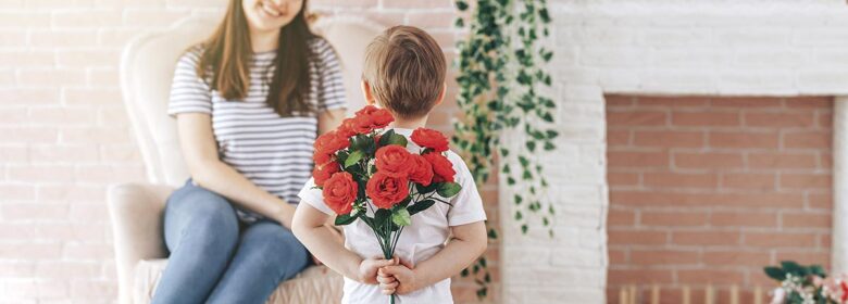 Boy holding a bouquet of flowers behind his back