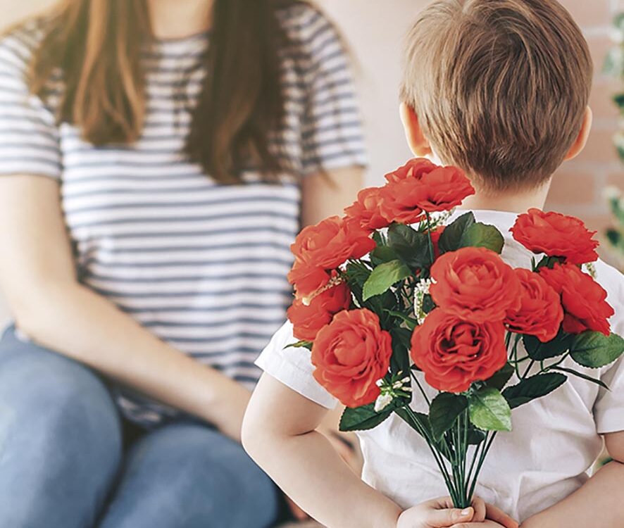 Boy holding a bouquet of flowers behind his back