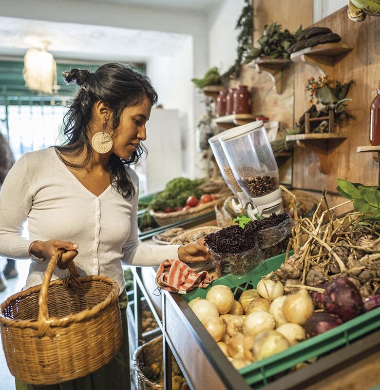Mid adult woman buying vegetables at small local store